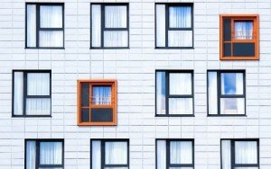 ściana budynku z oknami różnej wielkości i kolorze