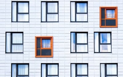 ściana budynku z oknami różnej wielkości i kolorze