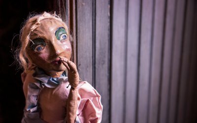 Stara kukiełka podnosi rękę zastanawiając się nad czymś, zapewne co jeszcze spakować